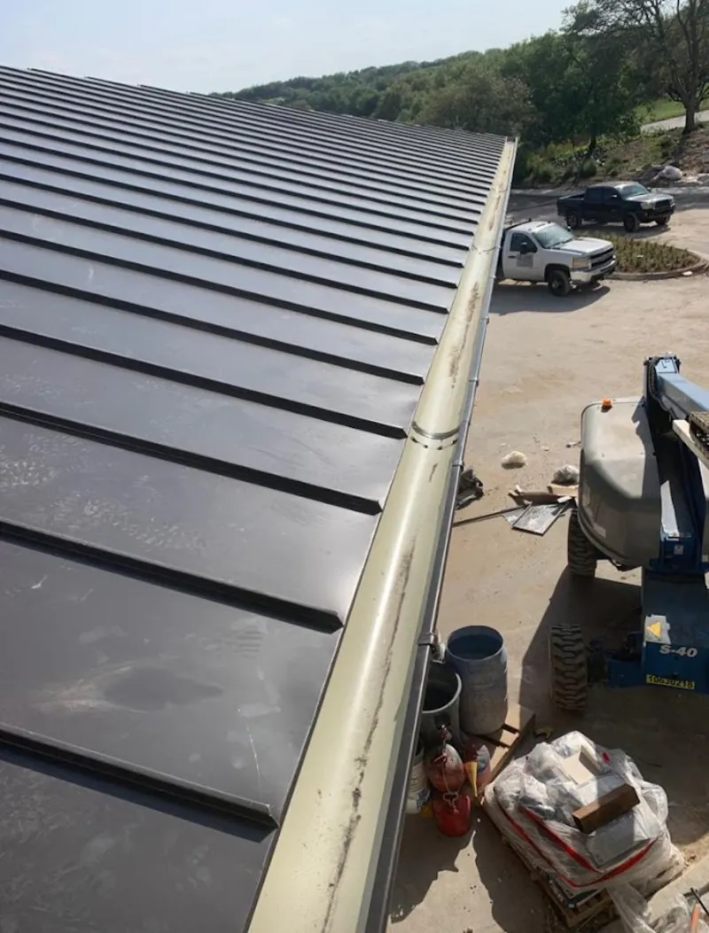 Standing seam panel and gutter detail on a metal roofing jobsite in San Elizario